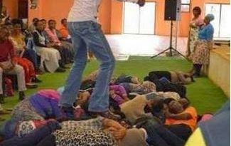 South African Pastor That Made His Members Eat GRASS Pictured Stepping On Members During Deliverance 6