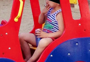 Shocking photos show 5yr old boy smoking & drinking can of beer in playground 2