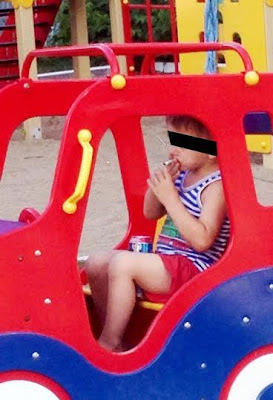 Shocking photos show 5yr old boy smoking & drinking can of beer in playground 2