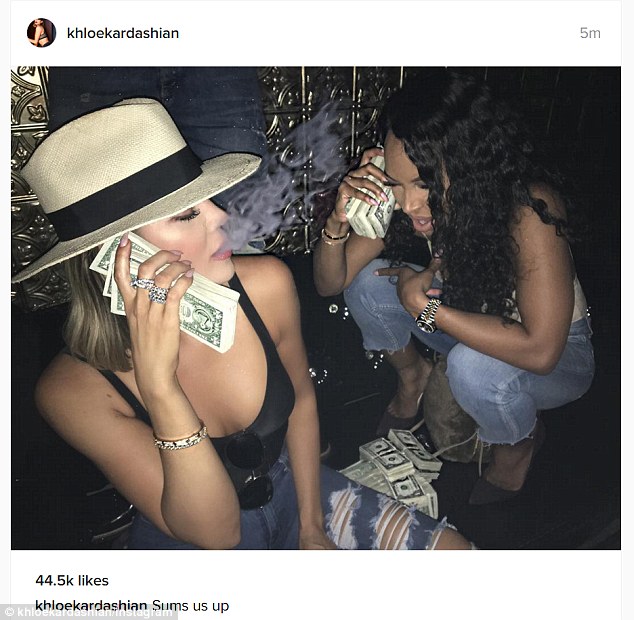 Khloe Kardashian exhales smoke while posing with wads of dollar bills in provocative snap 5